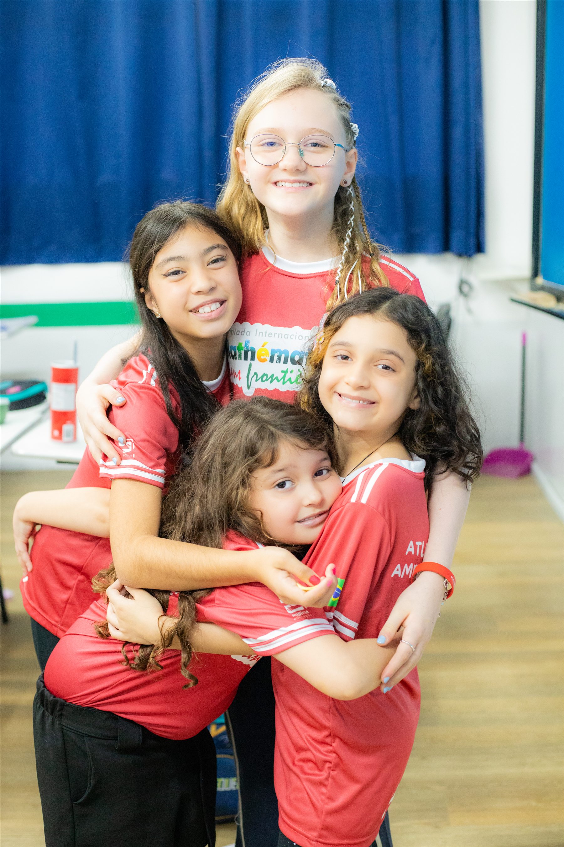 Quatro estudantes da Amplexo sorrindo e se abraçando